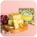 Farmhouse Mature Cheese with grapes on the chopping board 